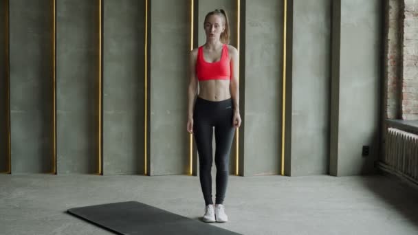 Athlète femme se tient debout et regarde la caméra et parle du but de l'entraînement. — Video