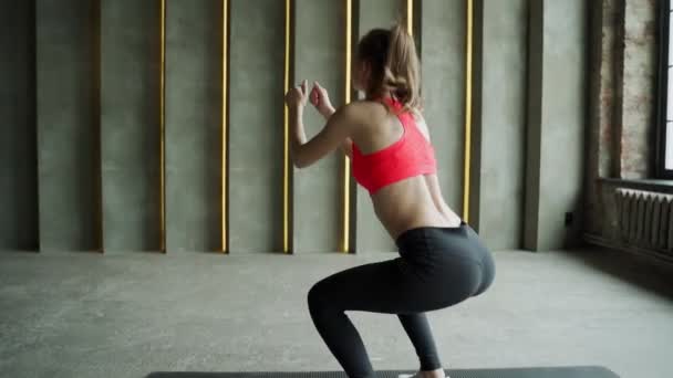 Jeune athlète femme en tenue de sport faisant squat à la salle de gym. Entraînement de fitness. — Video