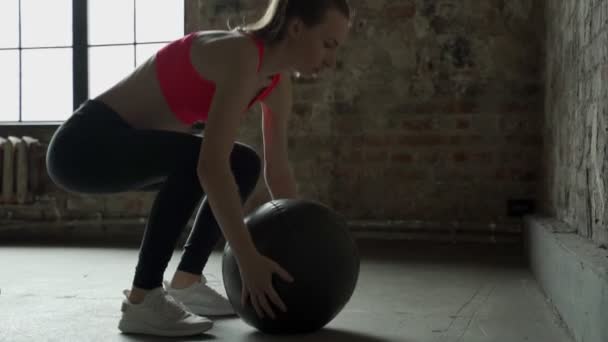 Athlète femme faire squats tout en jetant une boule de médicament contre un mur — Video