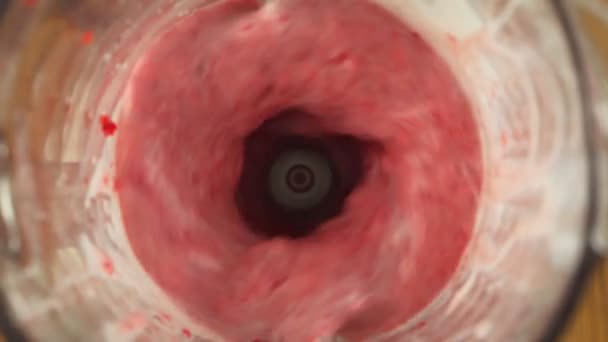 Close up fresh strawberry smoothie mixed in a blender, slow motion, top view — ストック動画