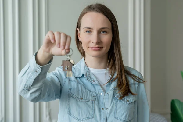 Счастливая хозяйка квартиры с ключами смотрит в камеру. Портрет счастливой женщины, въезжающей с ключами от новой квартиры — стоковое фото
