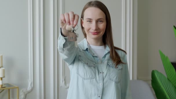 Mujer feliz dueño del apartamento con llaves mirando a la cámara. Retrato de la mujer feliz moviéndose en mostrar las llaves de nuevo apartamento — Vídeos de Stock