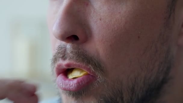 Primer plano de la boca de un hombre comiendo papas fritas — Vídeos de Stock