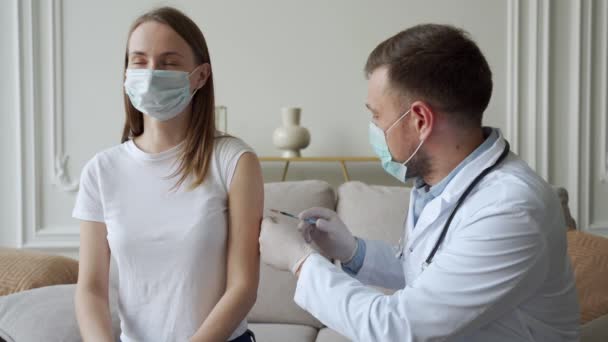 Dokter die antivirale injectie geeft aan de patiënt. Vrouw met medisch gezichtsmasker krijgt Covid-19 of griepvaccin in het ziekenhuis. — Stockvideo