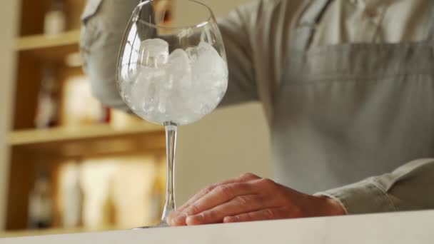 Närbild bartender omrörning is i glaset på bardisken — Stockvideo