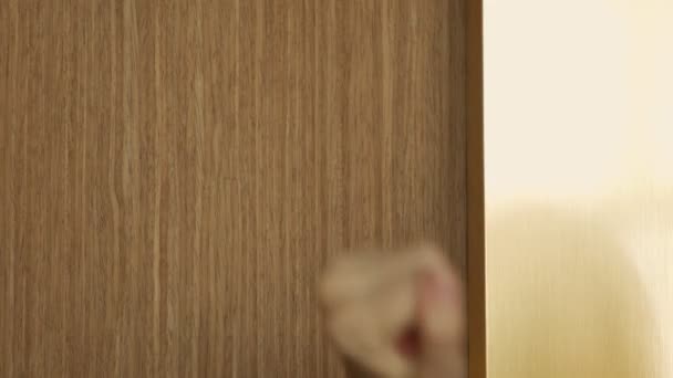 Detailní záběr ženské ruky bouchající na dřevěné dveře — Stock video