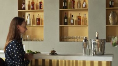 Erkek barmen müşteriye mojito kokteyli ikram eder ve müşteriyle iletişim kurar.