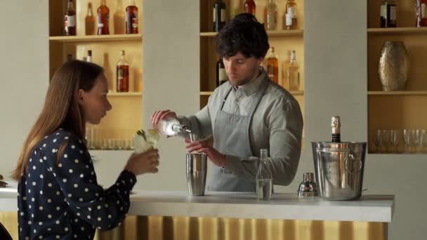 Pria bartender bekerja menyiapkan koktail di bar berbicara dengan klien wanitanya — Stok Video