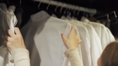 Kadın evdeki dolaptan bir gömlek seçiyor.
