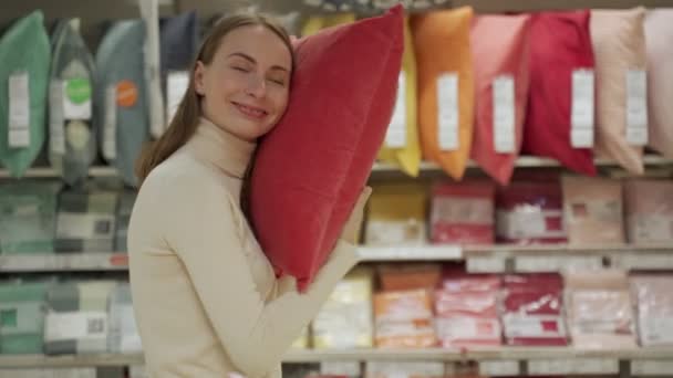 Morena elige una almohada en el estante de la tienda — Vídeos de Stock