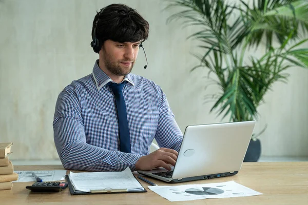 Empresario hablando con el equipo de colegas en videoconferencia. Hombre usando el ordenador portátil y auriculares para la reunión en línea. — Foto de Stock