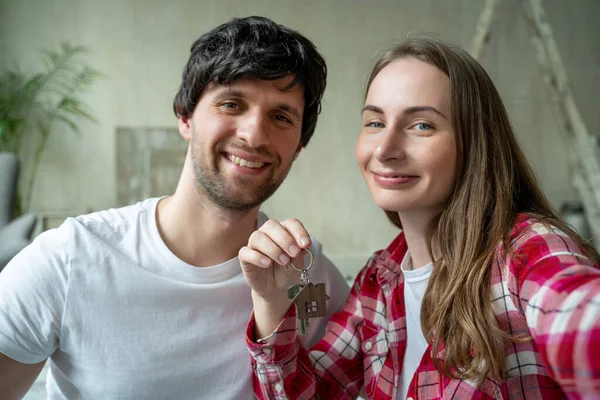 Семейная пара с гордостью показывает ключи от своего нового дома — стоковое фото