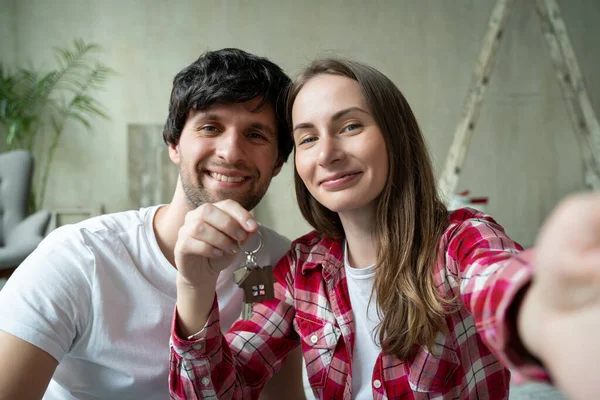 Familia pareja orgullosamente muestra las llaves de su nuevo hogar — Foto de Stock