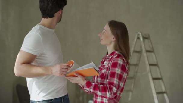 Coppia di famiglie discutendo una ristrutturazione di una casa con tavolozza di colori. — Video Stock