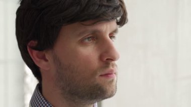 Yan bakan iş adamının yakın plan portresi. Kendinden emin genç adam yana bakıyor.