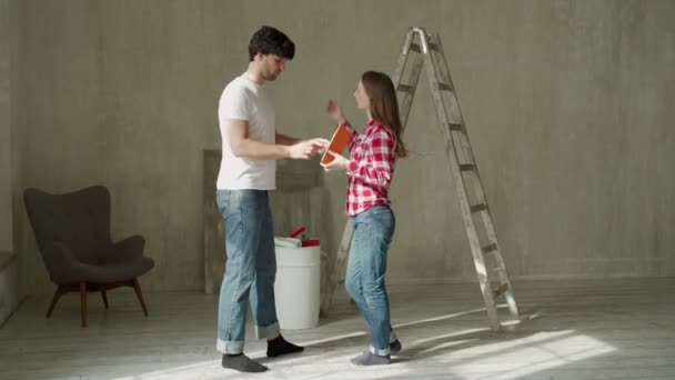 Couple familial discutant d'une rénovation d'une maison avec palette de couleurs. — Video