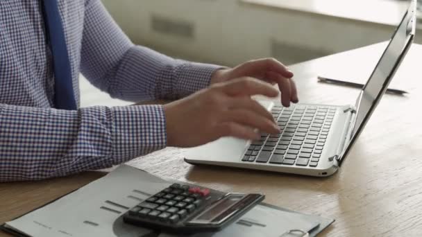 Close-up businessman using calculator and laptop for calculating finance, tax research — Stock Video