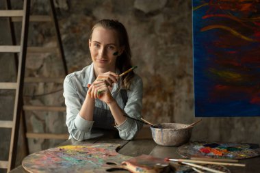 Profesyonel kadın sanatçı resim stüdyosunda çalışmaktan yoruldu..