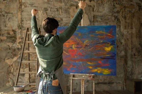 Artista maschio gioisce alla fine del lavoro, alzando le mani — Foto Stock