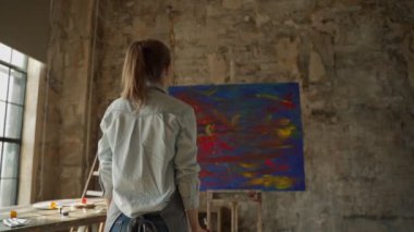 Kadın sanatçı çalışmanın sonunda ellerini kaldırarak seviniyor.