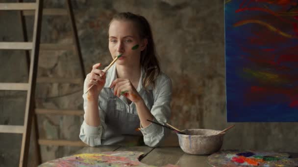 Artista femenina profesional cansada de trabajar en estudio de pintura. — Vídeos de Stock