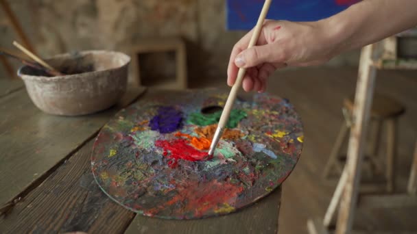 Kvinna konstnär borste blanda färg oljemålning på paletten och hon målar en bild — Stockvideo