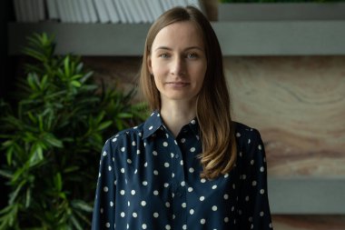 Ofiste duran tişörtlü çekici, zarif bir esmer.