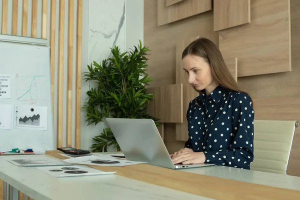 在办公室桌上工作的女商人在笔记本电脑上打字. — 图库照片