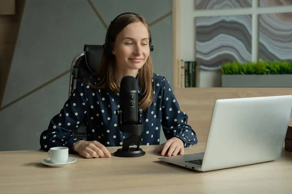 Mujer con micrófono y computadora portátil hablando y grabando podcast en el estudio — Foto de Stock