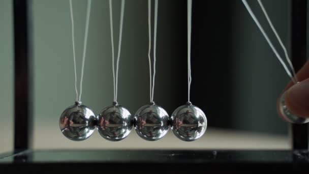 Hand verplaatsen Newtons ballen in het kantoor — Stockvideo