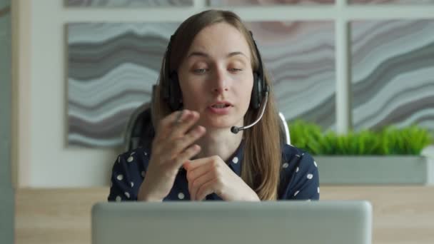 Mulher trabalhando online com fone de ouvido e laptop no escritório — Vídeo de Stock