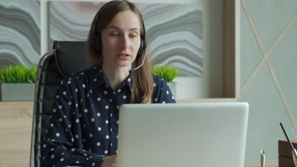 Ofisteki bilgisayarda görüntülü konuşma yapan genç bir kadın. — Stok video