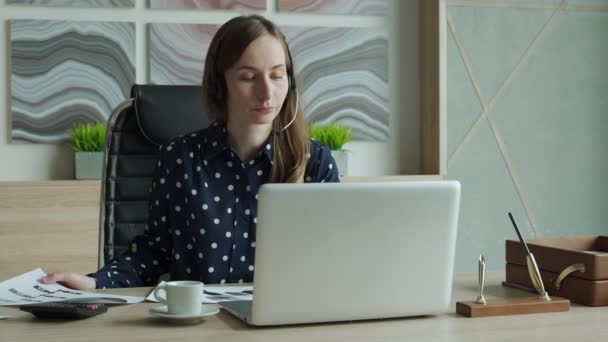 Jeune femme utilisant le chat vidéo sur ordinateur portable au bureau — Video