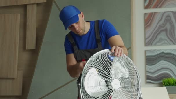 Elektrikář opravuje chladící ventilátor. Oprava vybavení v místnosti — Stock video
