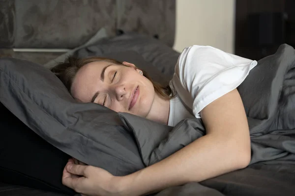 Ontspannen vrouw in de slaapkamer, heeft prettige dromen, houdt haar ogen dicht, geniet van een goede rust thuis — Stockfoto