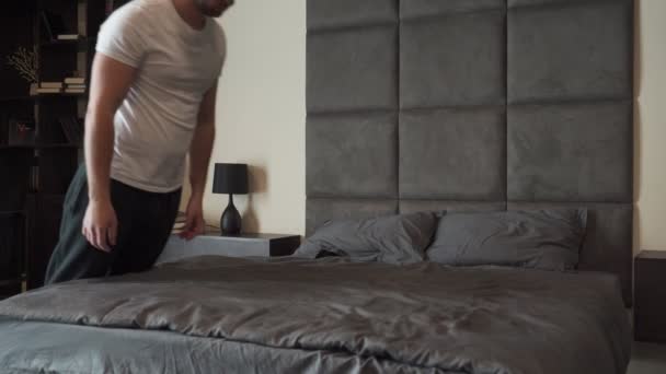 Moe persoon na een zware dag op het werk valt op het bed met zijn ogen dicht en slaapt in slow motion — Stockvideo
