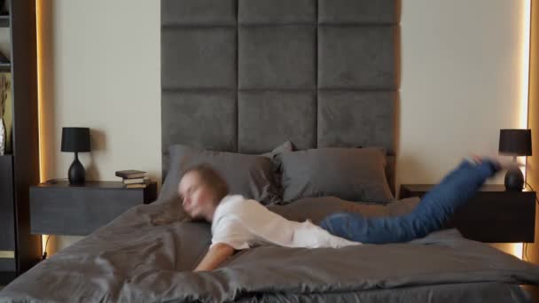 Müde Frau bricht auf dem Bett zusammen — Stockvideo