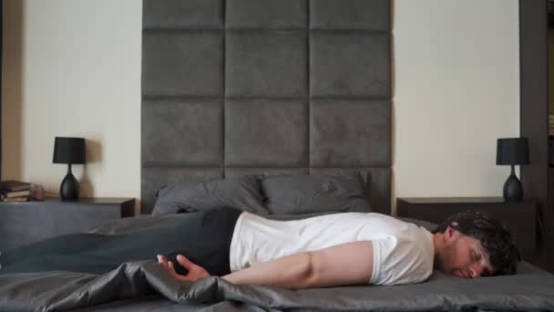 Homme fatigué après une dure journée de travail tombe sur le lit les yeux fermés et dort — Video