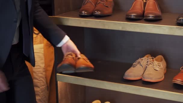 Homem escolhendo sapatos de moda na loja no centro comercial do departamento — Vídeo de Stock