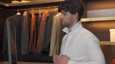 Yakışıklı adam soyunma odasında dikilirken bir gömlek giyer. Erkek buluşmadan önce şık bir gömlek giyiyor.