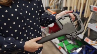 Dükkanda büyük bir balta almayı seçen bir kadının yakın çekimi.. 
