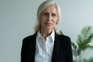 Portrait of a beautiful elderly woman who smiles and looks at the camera