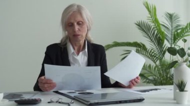 Senior mature business woman working stressed and frustrated at office computer laptop desk looking tired and overwhelmed in job problems and overwork