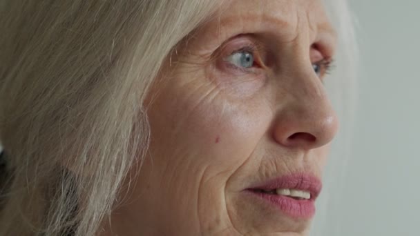 Счастливая пожилая женщина с седыми волосами, отводя взгляд, мечтает насладиться концепцией пенсионной жизни — стоковое видео