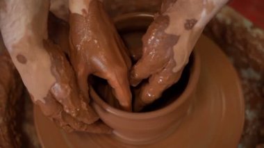 Çömlekçiliğe bir zanaatkarın ellerine rehberlik etmek çömlekçi çarkına çamur atmayı öğretmek. Öğretmen ve öğrenci konsepti