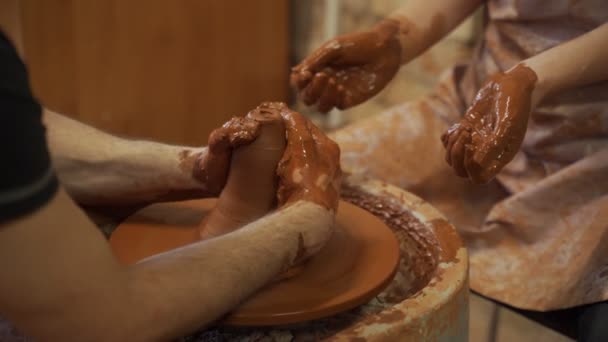 Yetenekli usta Potter 'ın elleri ve kadın elleri, Potter tekerleğindeki çömlek yapımı için kadının eğitimi. — Stok video