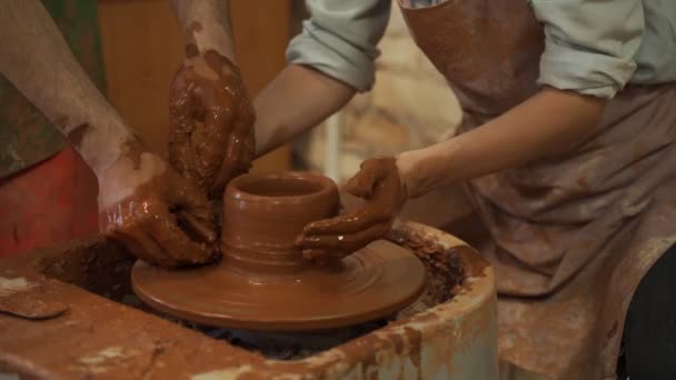 Aardewerk lessen, vrouw die klei pot op wiel maakt. Close-up van vuile handen, beeldhouwen klei servies masterclass aardewerk opleiding — Stockvideo