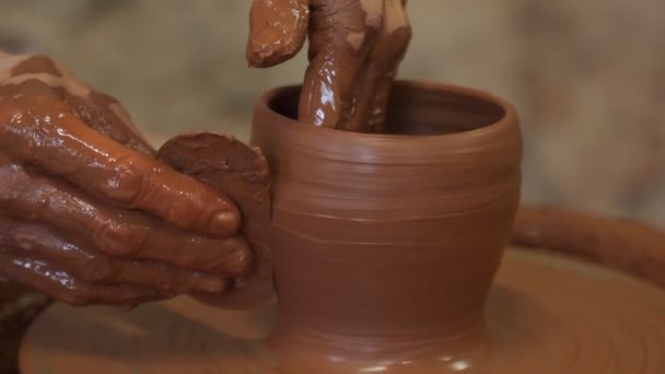 Vecchia donna ceramista che lavora su Potter ruota facendo una pentola di argilla. Maestro formando l'argilla con le mani creando pentola in un laboratorio — Video Stock