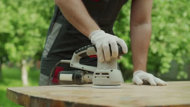 Gros plan menuisier masculin polit une table en bois avec une rectifieuse — Video