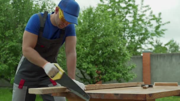 手を見て保護ツールとのこぎり付きの男性大工木材 — ストック動画